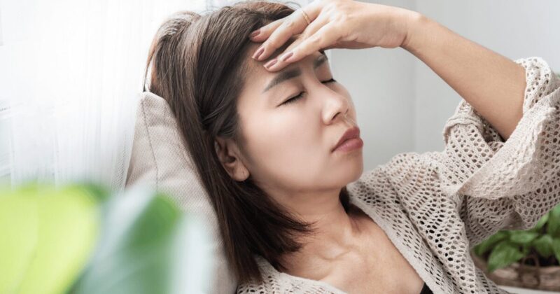 偏頭痛で横になる女性